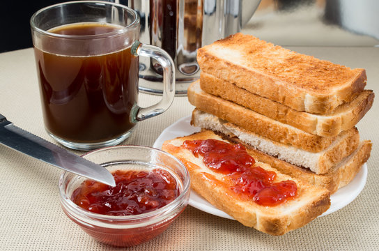 Hot toast with strawberry jam and transparent coffee mug