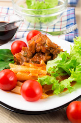 Detail of cooking pieces of stewed beef and penne pasta