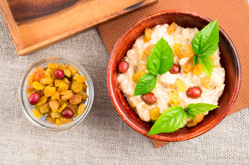 Healthy oatmeal with berries, raisins and herb
