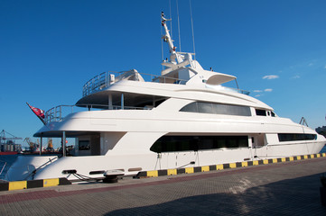 Naklejka premium White yacht in the port waiting. On the sea is calm.