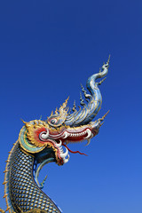Fototapeta na wymiar The blue head of naka or serpent statue opening mouth with blue sky background at Wat Rong Sua Ten at Chiang Rai, Thailand - Buddhist Temple 