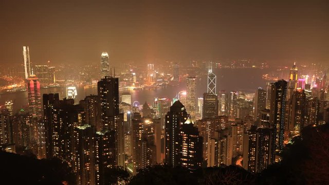 Aerial view time lapse of Victoria Harbour skyline by night from Lugard Road Lookout, the panoramic point most photographed. The Victoria Peak, the highest mountain in Hong Kong Island.