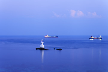 Commercial ship passing lighthouse