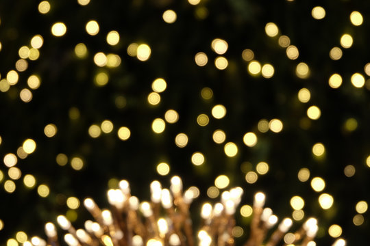 beautiful blurred flower shape light decoration design and bokeh light green christmas tree background, holiday abstract, blur defocused. look like fireworks celebration at night on new year's day.