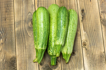 Green zucchini on wooden board