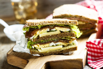 Homemade sandwich with smoked meat, egg and vegetables