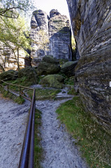 An iron railing going from one side of a rocky landscape
