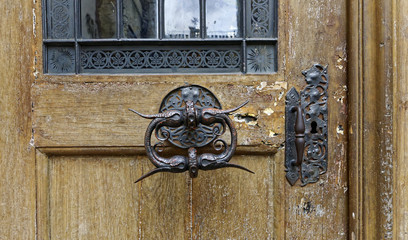 Antiquely designed door knob over a wooden door