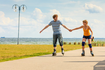 Young couple on roller skates riding outdoors