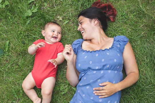 Overhead Shot Of A Mother Bonding With Her Baby Son On The Grass