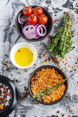 Ingredients for homemade soup with lentils, bulgur, tomatoes, peppers, herbs on a gray marble background. Top view. The concept of home seasonal food.