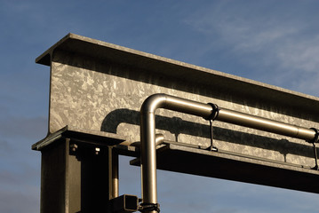 sichtbar verlegte Wasserleitung am Yachthafen, Metallträger im Sonnenschein