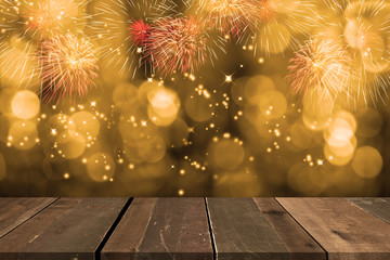 Fireworks blowing up in the sky with bokeh behind empty wooden table.
Concept of  Celebration...