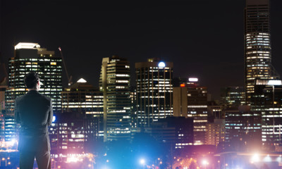 Businessman viewing night glowing city