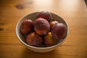 Fresh plums in bowl.