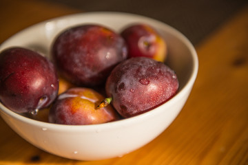 Fresh plums in bowl.