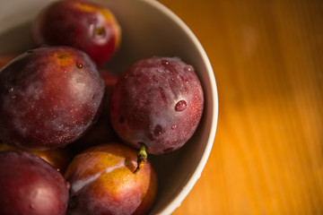 Fresh plums in bowl.