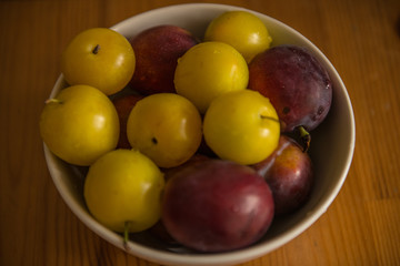 Top view of fresh plums in bowl