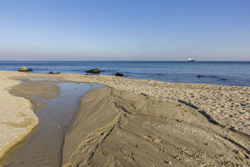 Day view of a small river flowing into the sea