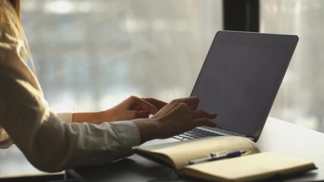 Close-up of busy female hand typing on keyboard while sitting at her working place in the office