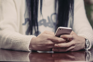 Woman texting on her mobile phone at coffee shop