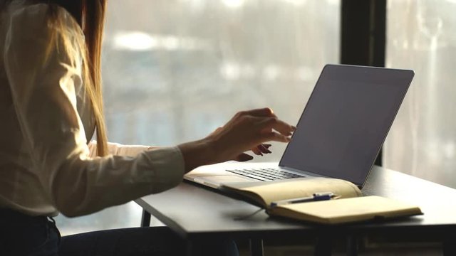 Close-up of busy female hand typing on keyboard while sitting at her working place in the office