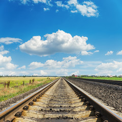 Fototapeta premium railroad goes to horizon in blue sky with clouds