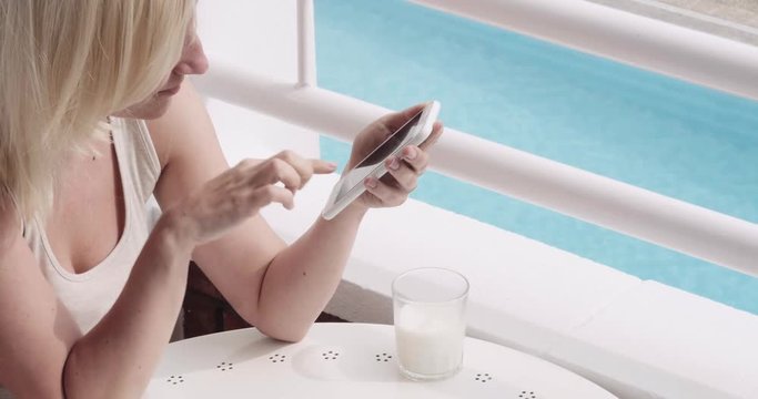 Woman Using the smartphone and drinking milk