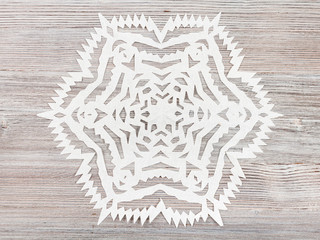 snowflake carved from paper on light brown table