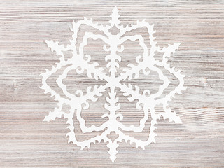 snowflake cut out of paper on light brown surface