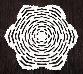snowflake carved from paper on dark brown surface