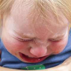 portrait of emotional tears crying baby toddler blond long hair