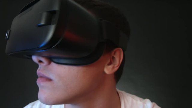 Close-up shot of a young man wearing VR Headset experiencing virtual reality. Captured with Blackmagic Production Camera 4K with RAW settings.