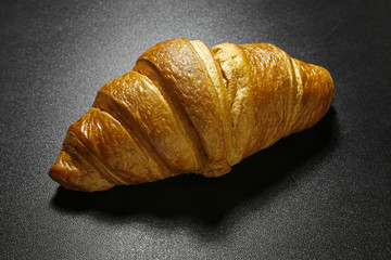 closeup of croissant on black background