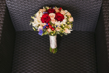 Bridal morning details. Wedding bouquet of red, beige and pink flowers with berries.