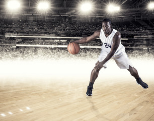 Fototapeta premium A strong athletic professional basketball player skillfully dribbling up the court. Clean white background. Lots of copy space