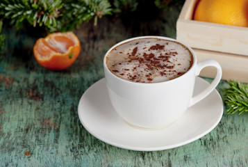 A cup of coffee on a wooden background. Coffee cappuccino with Christmas decorations and fir branches on the old wooden background. Cocoa Cappuccino Coffee Cup of coffee Wooden background
