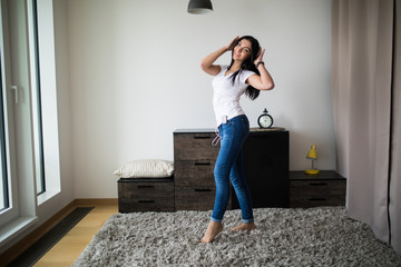 Sexy brunette woman listen music and dancing in her room at home