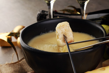 Dipping into a delicious cheese fondue made with a blend of assorted melted cheeses and wine or cider