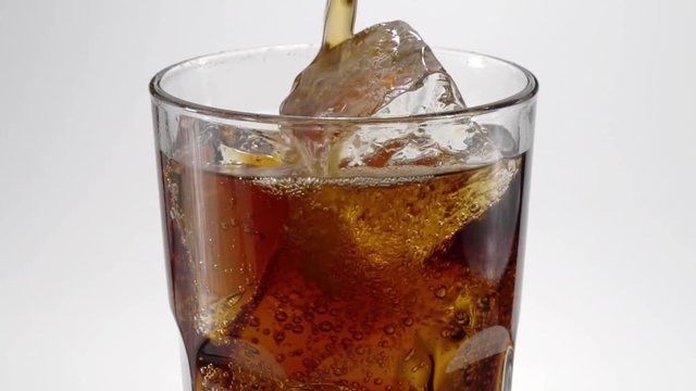 Slow-motion cola poured in a glass.