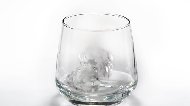 Whiskey poured into a glass with ice. Slow motion. 120fps