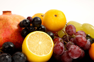 lemon, grapes and pomegranate on white background