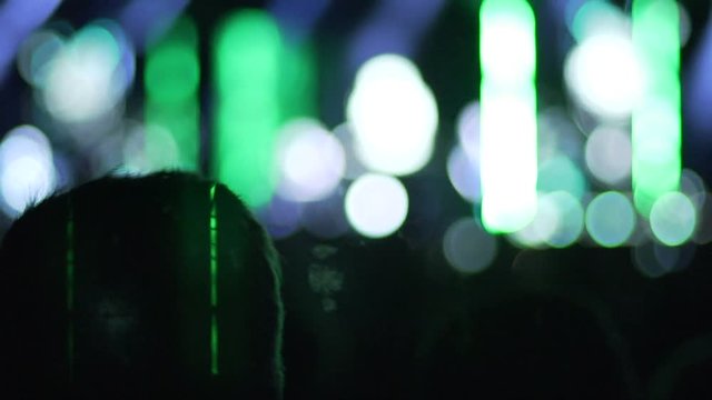 Creative illumination effects at show, silhouettes of people watching concert