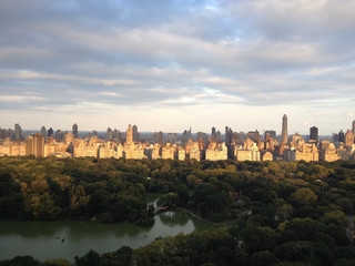 Fototapeta na wymiar Warm light at sunset on the buildings of the Upper East Side and Central Park.The Lake and the Ramble of Central Park in Manhattan, New York City.