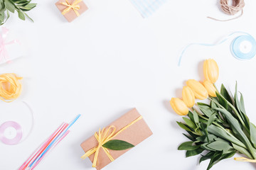 Bouquet of yellow tulips, boxes with gifts, ribbons and rope on