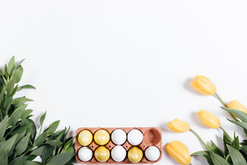 Tray with Easter eggs and yellow tulips on a white background, s