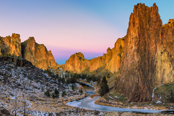 Winter sunrise at Smith Rock State Park with a dusting of snow and a frozen Crooked River. 