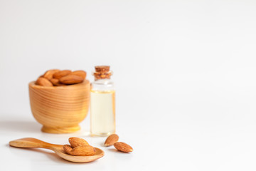 cosmetic almond oil in glass bottle on white background