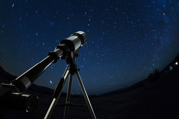 Telescope pointed to the clear night sky and stars