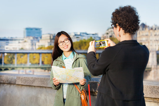 Woman taking photo of her friend near Seine